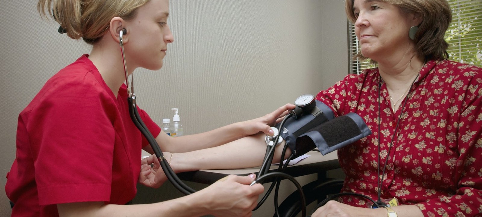 Clinician checking an older woman's blood pressure