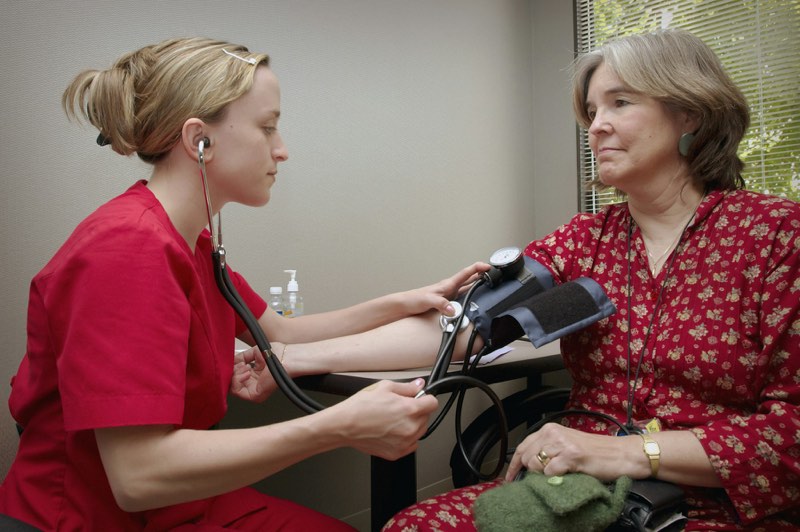 Clinician checking an older woman's blood pressure