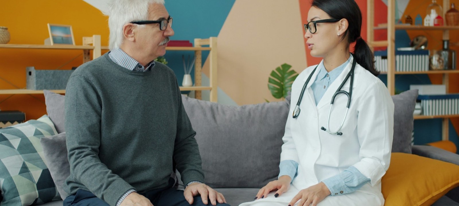 Doctor talking with an older man on a couch