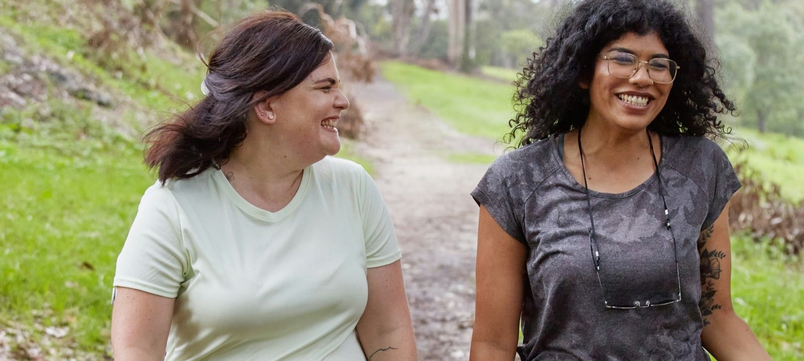Two women laughing together on a walk outdoors