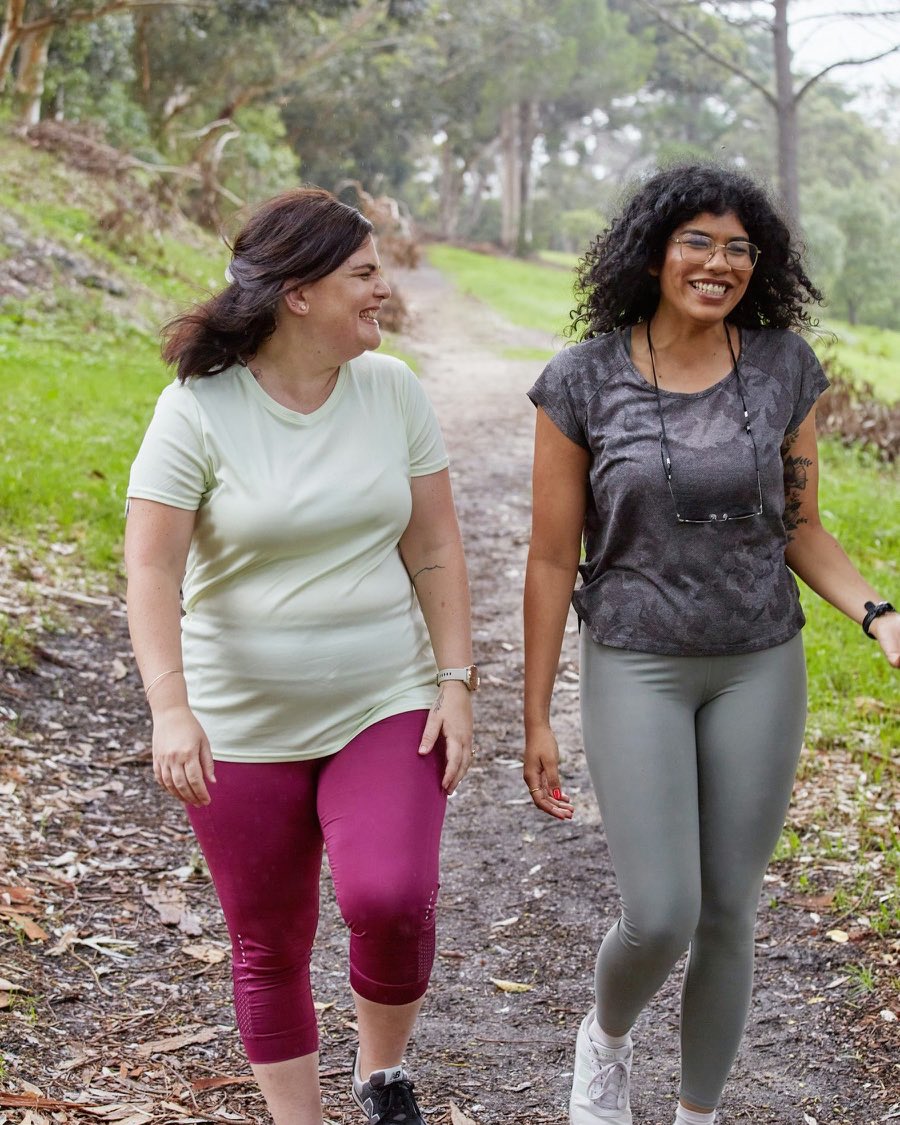 Two women laughing together on a walk outdoors